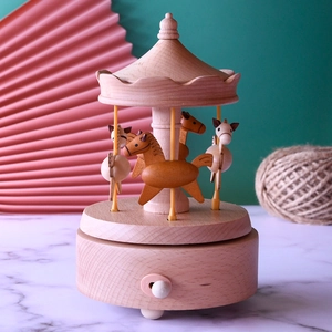 Rotating wooden carousel music box with carved horses and natural wood grain texture