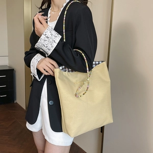 Fashionable beige canvas tote bag with colorful beaded strap and plaid lining