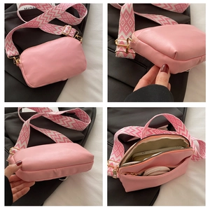 Detail view of pink crossbody bag with geometric wide strap and internal compartments