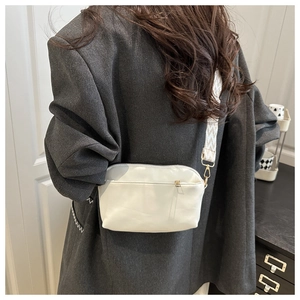 Détail d'un sac bandoulière en cuir PU blanc avec une large bandoulière géométrique