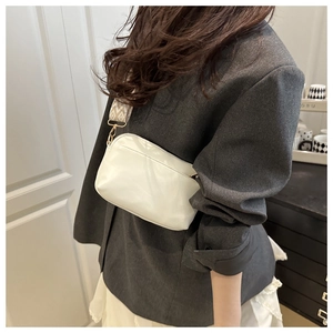 Détail du sac bandoulière blanc avec sangle jacquard vintage et finitions dorées