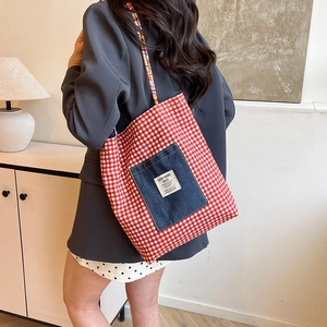 Red checkered canvas tote bag with denim front pocket and woven rope shoulder straps