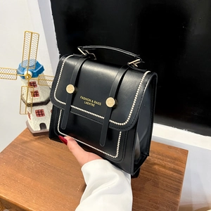 Retro black leather backpack with gold hardware and flap closure for fashion students