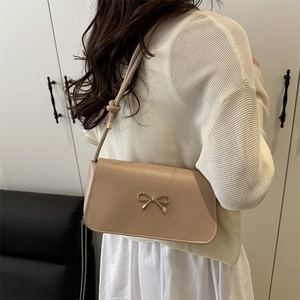 Elegant beige shoulder bag with gold bow detail and pleated knots for women's summer style