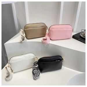 Detail view of multi-color crossbody bags with stylish woven wide shoulder straps