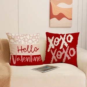 Valentine's Day pillow covers with Hello Valentine and XOXO prints on a cozy sofa