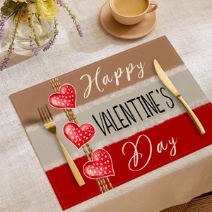 Detail der Leinen-Tischmatte zum Valentinstag mit roten Herzen und goldenem Besteck