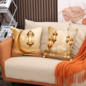 Set of two Ramadan pillow covers with golden moon and lantern prints on a sofa