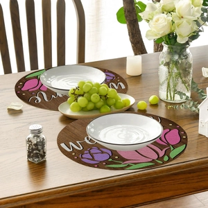 Detailed close-up of linen-textured round placemats with pink tulip floral and Welcome text