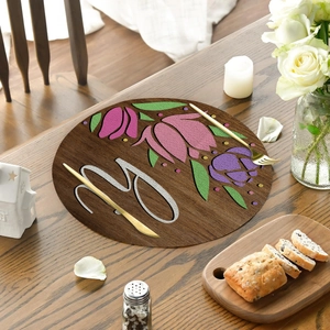 Detail of round linen placemat with wood grain pattern, floral design and letter Y