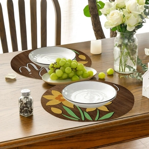 Close-up of rustic round linen placemats with yellow floral design and wood texture