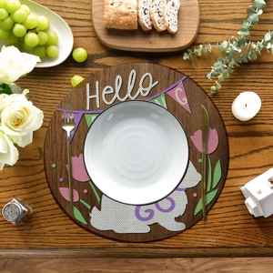 Macro detail of Easter round placemat with white rabbit, purple tulips and Hello lettering