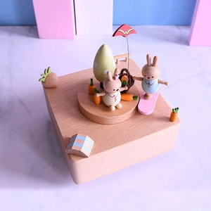 Mechanical wooden music box with rotating rabbit figures and colorful hand-painted details