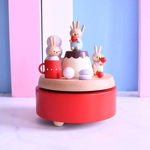 Exquisite wooden music box with colorful rabbit figures on a rotating red base