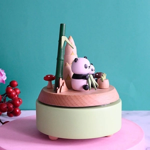 Handcrafted wooden panda music box with bamboo trees and forest scene revolving on a base
