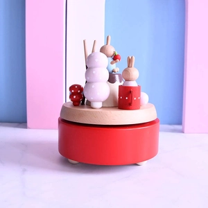 Handcrafted wooden Christmas music box with cute rabbits and mushrooms on a red base