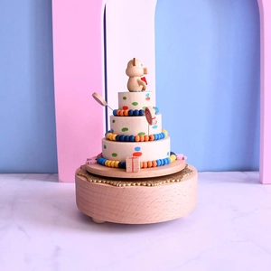 Three-layer wooden cake music box with a cute bear topper and colorful wooden beads