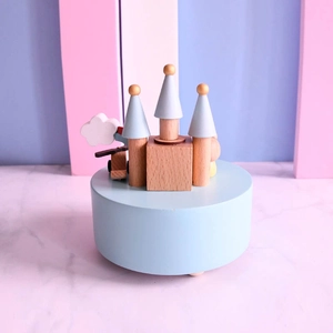 Blue wooden castle music box with rotating helicopter on pastel pink marble background