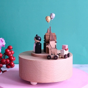 European wooden musical box with rotating figures and a church on a blue background