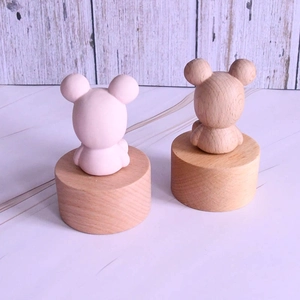 Cute bear wooden music box with natural grain and pink decorative ornaments on round base