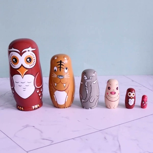 Detail view of 6-piece wooden owl nesting dolls featuring vibrant animal hand-painted designs