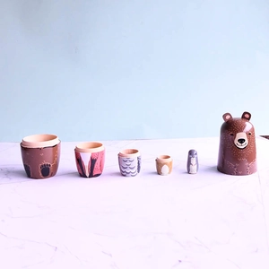 Detail view of a 5-layer animal nesting dolls featuring brown bear and fox wooden designs