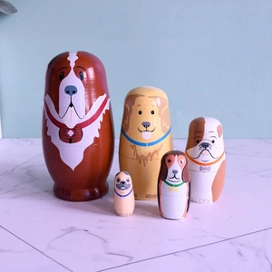 Détail de 5 poupées russes en bois peintes à la main motif chien sur marbre blanc