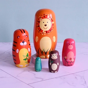 Détail de cinq poupées russes en bois avec motifs d'animaux lion et tigre