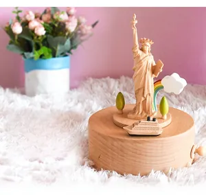 Detailed wood-carved Statue of Liberty music box on a plush surface with home decor background