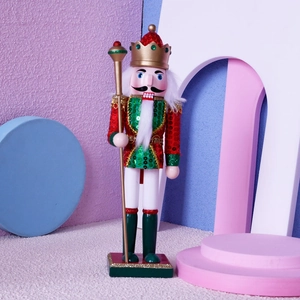 Close-up of a 30cm wooden nutcracker with red and green sequins and a golden scepter