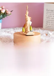 Detailed close-up of 3D wooden Statue of Liberty music box with ship and tree miniatures
