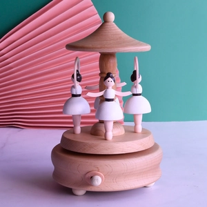 Wooden spinning ballet music box with three ballerina dancers on a pink floral background