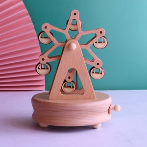 Macro shot of wooden ferris wheel music box with vintage mechanical wind-up clockwork base