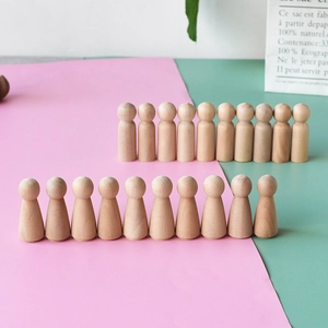 Macro shot of unfinished smooth wooden peg dolls for DIY painting and crafts