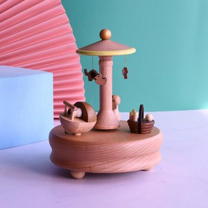Detailed close-up of wooden music box with carousel horses, elephants and duck charms