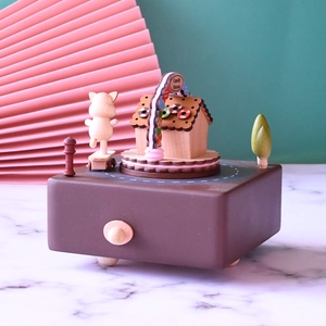 Detailed view of rotating wooden music box with Candy House and skating pig figurine