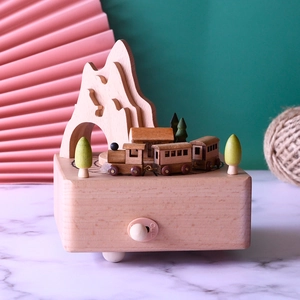 Detailed craftsmanship of a wooden mountain train music box with trees and switch