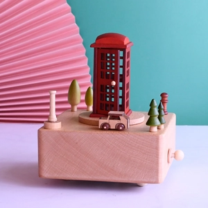 Wooden music box with red telephone booth and miniature car on a rotating base