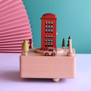 Detail of wooden music box featuring red telephone booth and miniature car scene