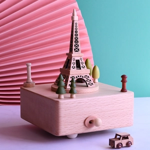 Detailed macro view of a wooden Eiffel Tower music box with a miniature car and on/off switch