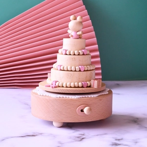 Dettaglio di un carillon in legno a tre strati a forma di torta con un piccolo orso