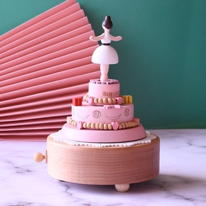 Wooden ballerina music box featuring a pink three-layer cake design with a spinning dancer