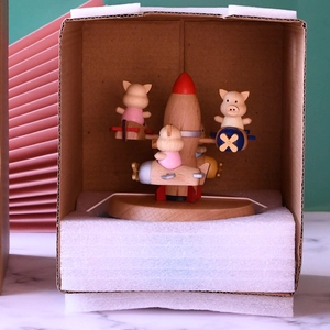 Handcrafted wooden pig pilot music box featuring a rotating rocket and colorful mini aircrafts