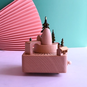 Macro detail of wooden musical box with miniature trees and houses on a solid beech base