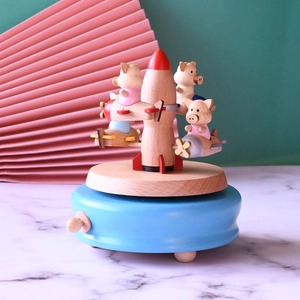 Detailed view of colorful wooden music box featuring cute pigs in airplanes and a rocket