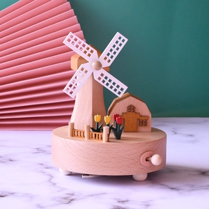 Detail of wooden windmill music box featuring intricate tulips and a rotating mechanism