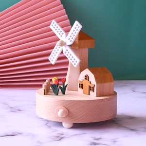 Dutch windmill wooden music box with tulips and miniature house on marble surface