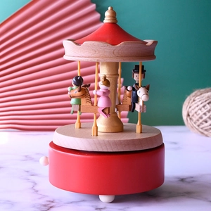 Mechanical wooden carousel music box in red finish with hand-carved details
