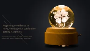 Macro shot of luminous crystal ball lamp with internal clover engraving and wooden base