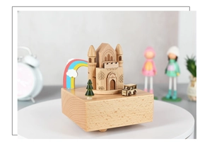 Detalle de una caja de música de madera artesanal con un castillo tallado y decoración arcoíris